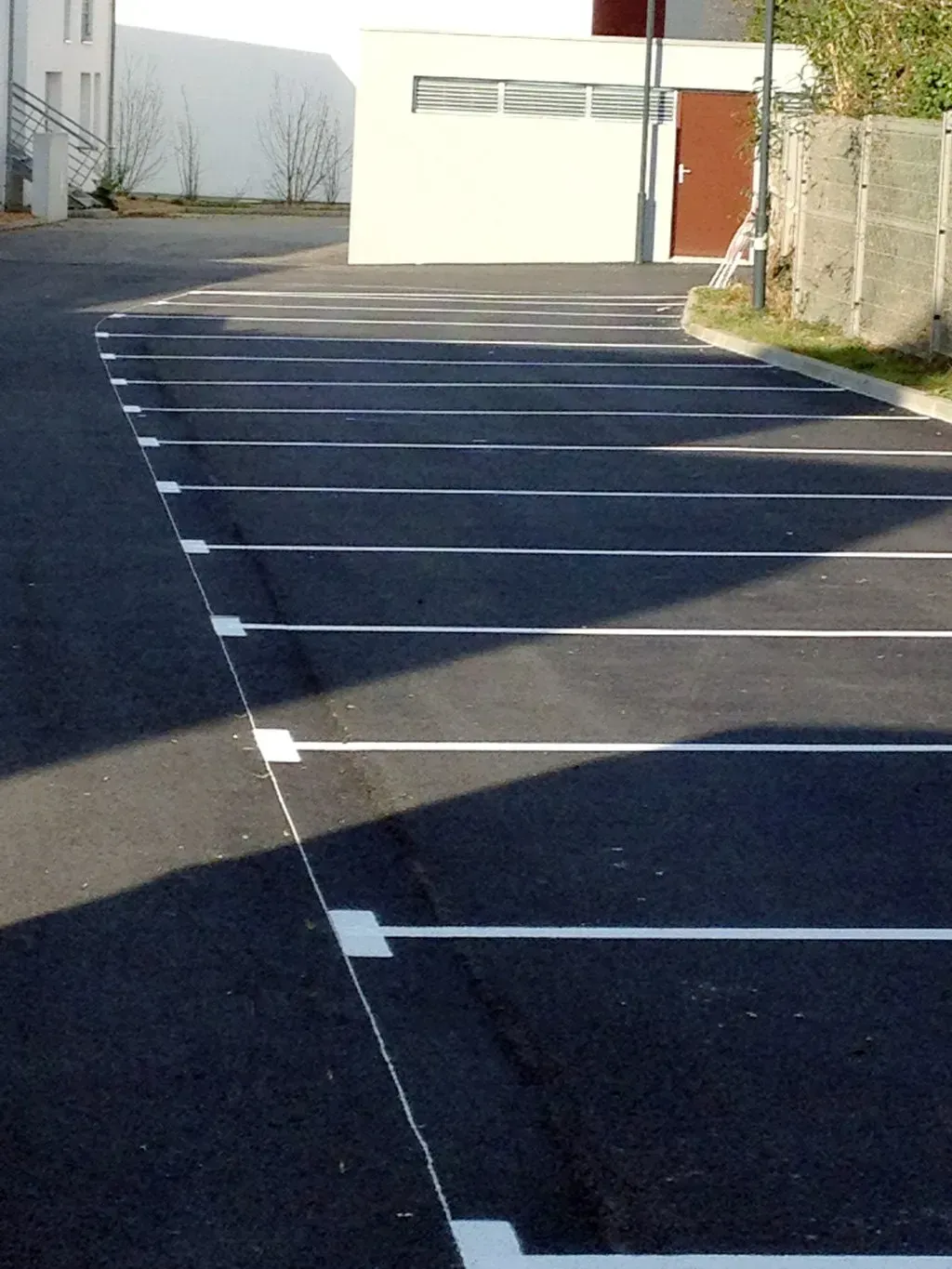 Signalisation horizontale en blanc proposant plusieurs rangées pour garer des voitures