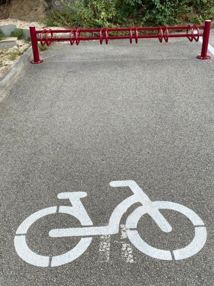 Marquage d'un vélo blanc au sol avec barrière rouge pour indiquer une piste uniquement cyclable