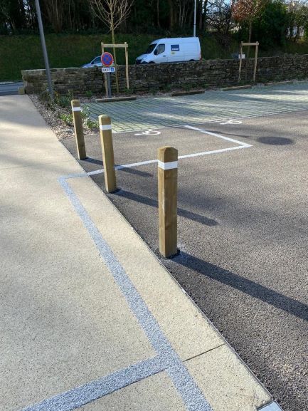 Piliers en bois rectangulaire protégeant les zones piétonnes des véhicules