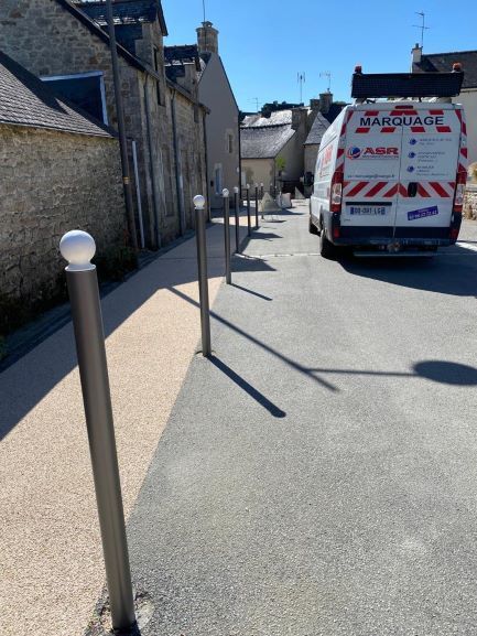 Intervention d'ASR et son camion pour la mise en place d'un mobilier urbain de protection d'un trottoir le long d'une route