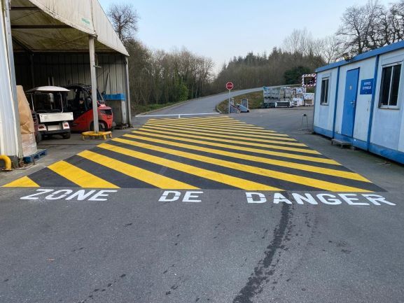 Intervention de marquage au sol jaune et noir pour indiquer une zone de danger