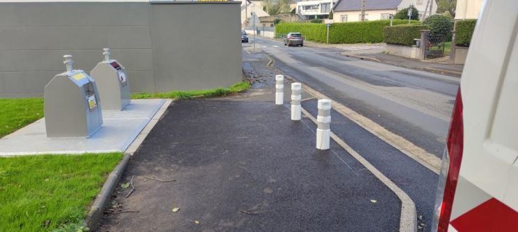 Mobilier urbain de bornage devant des espaces de tri des déchets