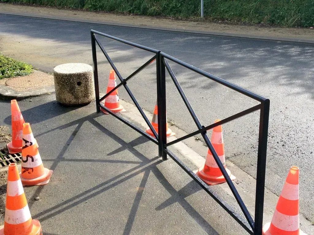 Rambarde dans la rue entourée de plots de chantier