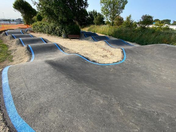 Virage bordé en bleu d'une piste servant aux vélos avec des bosses
