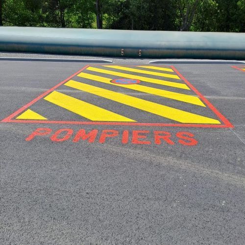 Zone marquée au sol en rouge ou noir pour le stationnement des pompiers