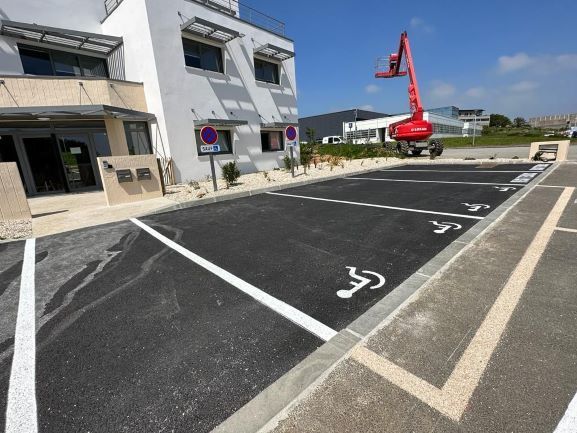 Marquage au sol en blanc de places de parking dont trois pour les PMR et deux réservés aux professionnels