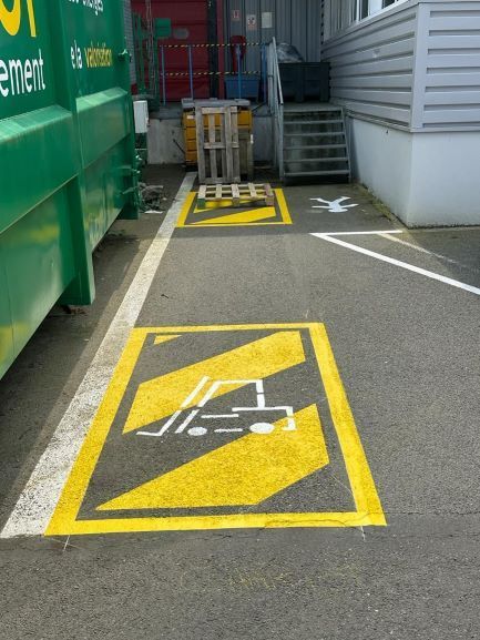 Marquage au sol en entreprise pour la zone à utiliser par les monte-charges devant les bennes à ordure