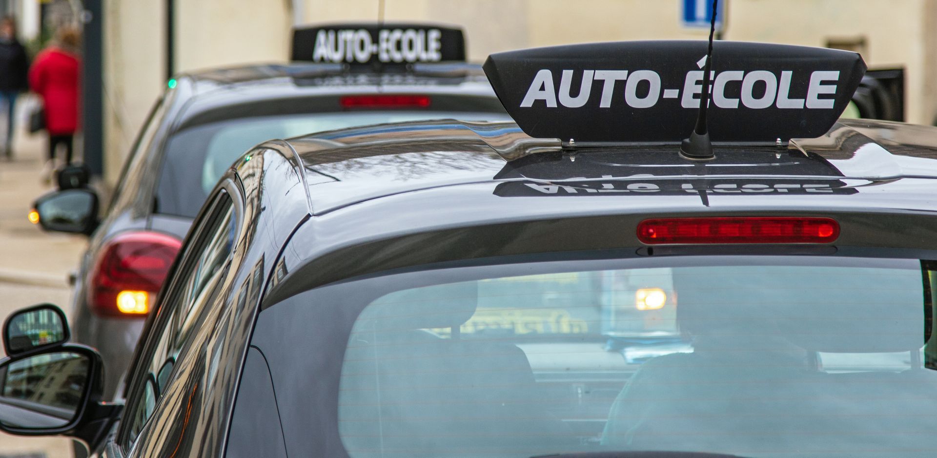 Voiture avec l'insigne auto-école sur le toit.