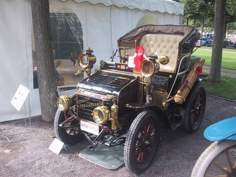 Ein altes Auto steht vor einem weißen Zelt