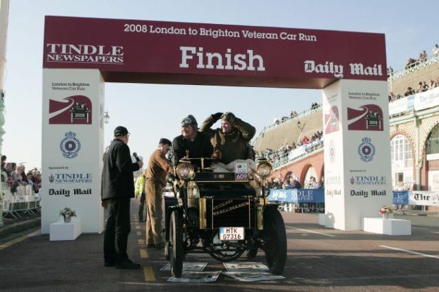 Eine Gruppe von Menschen steht unter einem Banner mit der Aufschrift „Fertig“