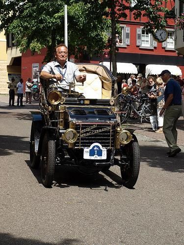 Ein Mann fährt ein altes Auto mit der Nummer 1 auf der Vorderseite