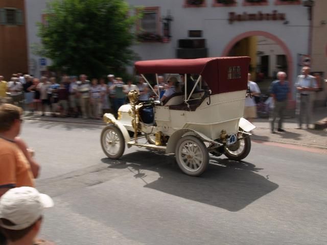 Ein weißes Auto mit rotem Verdeck fährt eine Straße entlang