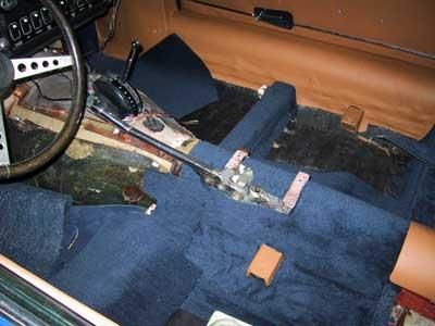 Der Innenraum eines Autos mit einem blauen Teppich und einem Lenkrad.