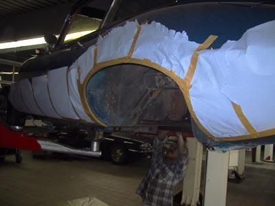 Ein Mann arbeitet in einer Garage an einem Auto.