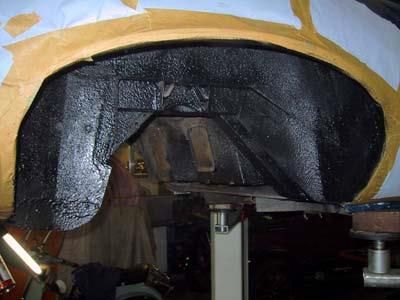 In einer Garage wird ein Kotflügel eines Autos lackiert.