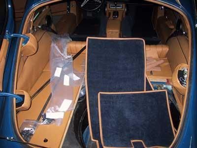 Das Innere eines blauen Autos mit Teppichen auf dem Boden.