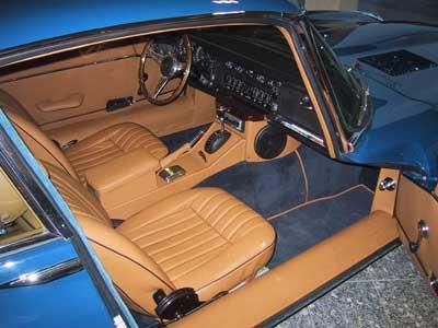 Der Innenraum eines blauen Autos mit braunen Ledersitzen und einem Lenkrad.