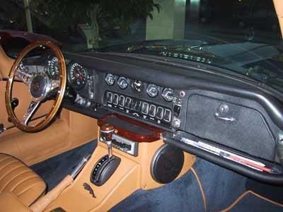 Der Innenraum eines Autos mit Holzlenkrad und Armaturenbrett.