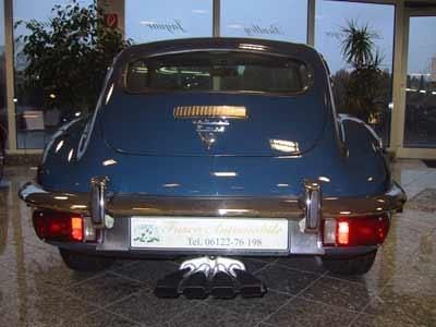 Ein blaues Auto ist vor einem Fenster geparkt