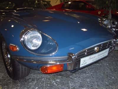 Ein blauer Jaguar E-Type-Sportwagen steht in einer Garage.