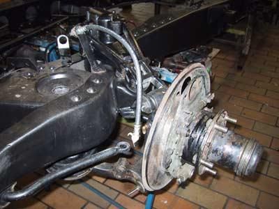 Eine Nahaufnahme einer Bremsscheibe an einem Auto in einer Garage.