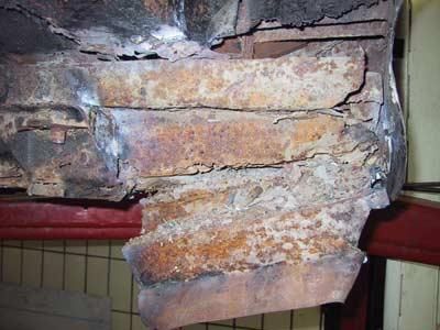 Ein Stück rostiges Metall liegt auf einer Ziegelmauer.