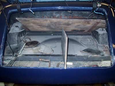 Das Heck eines blauen Autos mit geöffnetem Kofferraum.