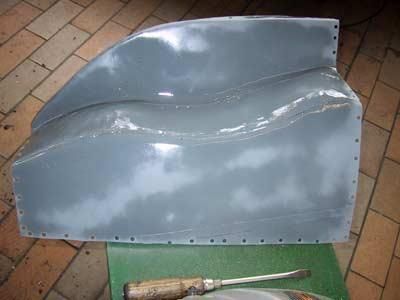 Auf einem Tisch liegt ein Stück Plastik neben einem Schraubenzieher.