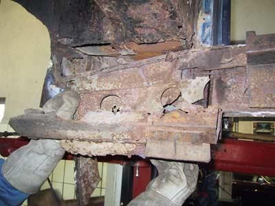 Eine Person mit Handschuhen arbeitet an einem rostigen Stück Metall.