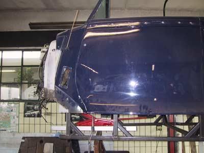 Ein blaues Auto steht auf einem Metallständer in einer Garage.