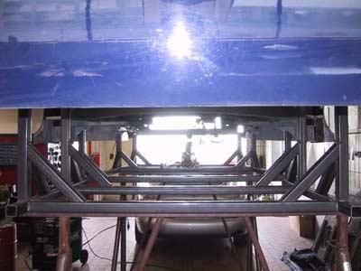 In einer Garage wird auf einem Metallrahmen ein Auto gebaut.