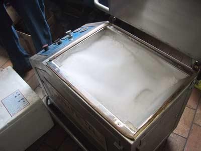 Eine Person steht neben einer Maschine, die auf einem Tisch steht.