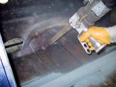 Eine Person verwendet eine Säge, um ein Stück Metall zu schneiden.