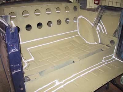 In einer Garage mit vielen Löchern wird ein Auto gebaut.