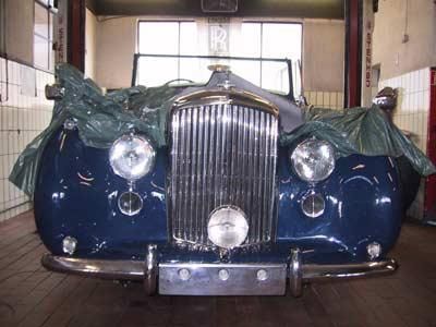 Ein blaues Auto ist in einer Garage in Plastik eingewickelt