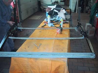 Ein Mann arbeitet an einem Holztisch in einer Garage.