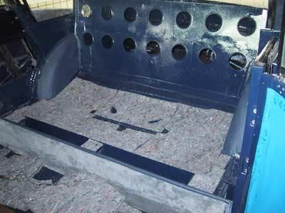 Das Heck eines blauen Autos mit vielen Löchern.