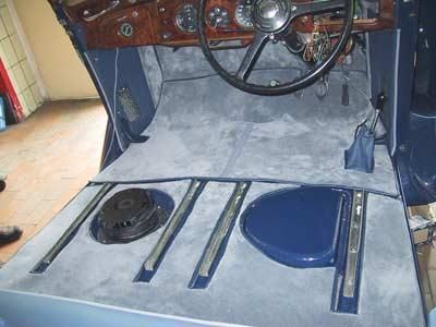 Das Innere eines Autos mit einem Lenkrad und einem blauen Sitz.