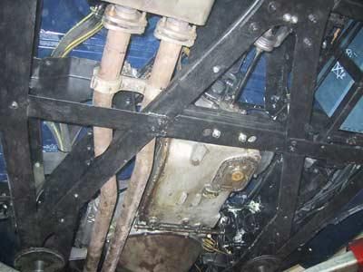 Eine Nahaufnahme der Unterseite eines Autos, auf der der Motor und die Auspuffrohre zu sehen sind.