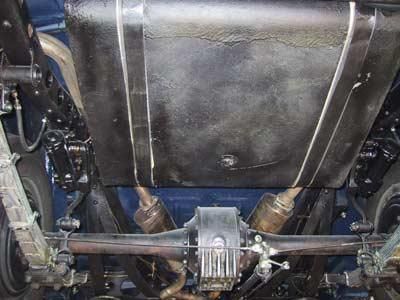 Die Unterseite eines Autos mit Kraftstofftank und Auspuffrohren.