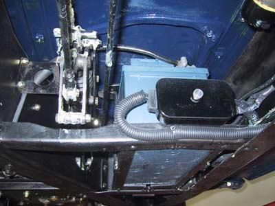 Unter einem Auto liegt eine blaue Batterie.