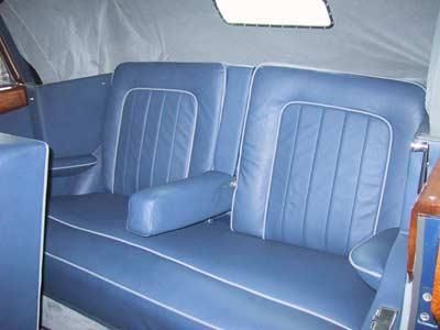 Der Rücksitz eines Autos mit blauen Ledersitzen