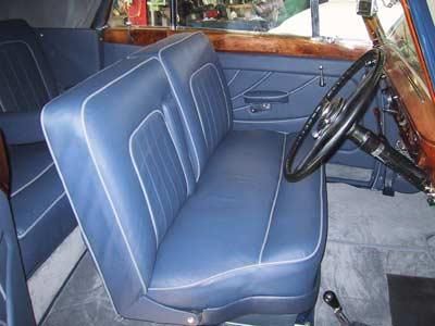 Der Innenraum eines Autos mit blauen Sitzen und einem Lenkrad.