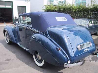 Ein blaues Auto mit Cabrioverdeck steht auf einem Parkplatz.