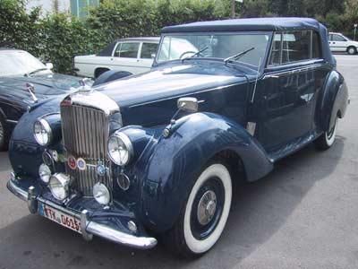 Ein blaues Auto mit weißen Reifen steht auf einem Parkplatz