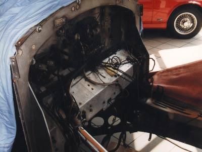 Ein rotes Auto ist hinter einem Auto mit offener Motorhaube geparkt