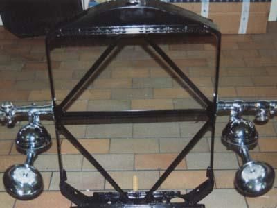 Ein schwarzer Metallrahmen mit Chromrädern steht auf einem gefliesten Boden