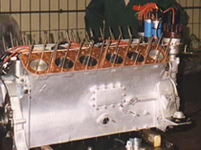 Ein Mann arbeitet in einer Fabrik an einem großen Motor.