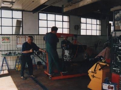 Zwei Männer arbeiten an einer Maschine in einer Garage