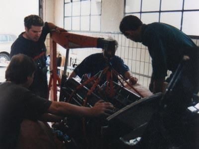 Eine Gruppe von Männern arbeitet an einem Automotor